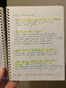 Alt text: Photo of Maegan's spiral bound journal, showing her intentions written in cursive and green ink.