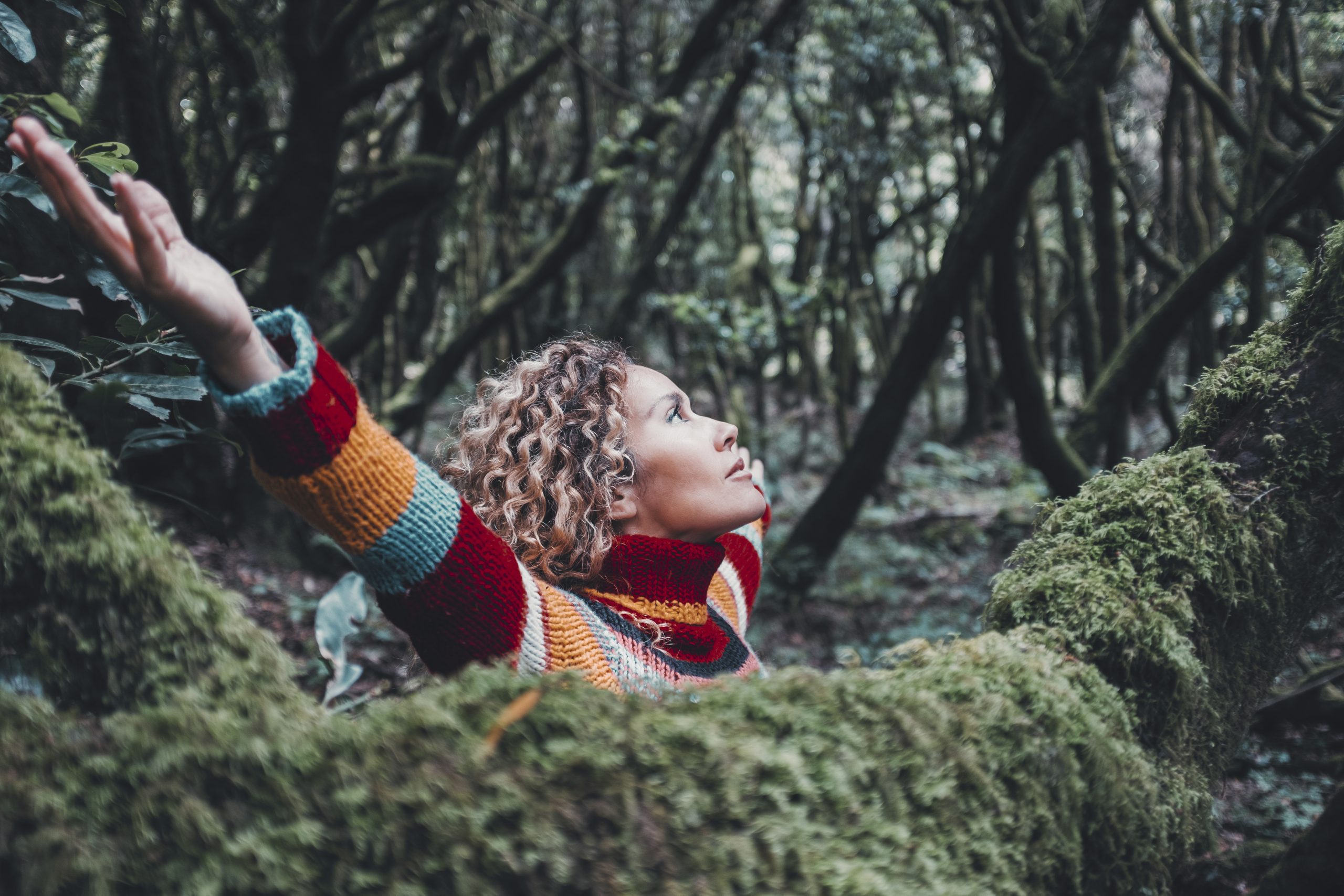 Woman celebrating nature lifestyle and outdoor leisure activity alone opening arms outstretching
